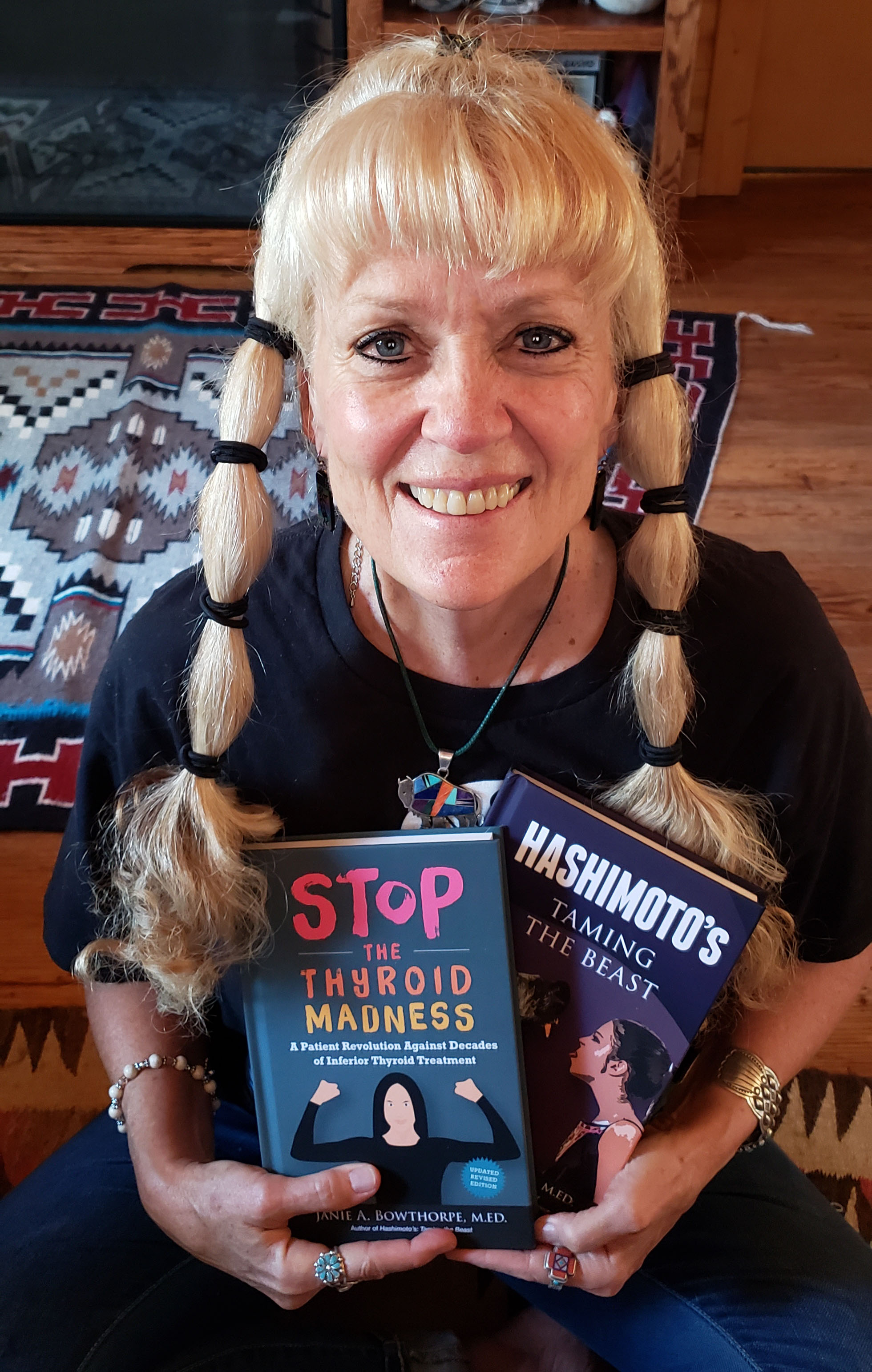 janie bowthorpe smiling, holding two books